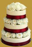 tort weselny w stylu tradycyjnym na stelażu wypełnionym pięknymi żywymi różami