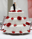 tort weselny z czerwonymi płatkami róż