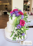 Tort weselny w stylu boho z żywymi fioletowymi kwiatami